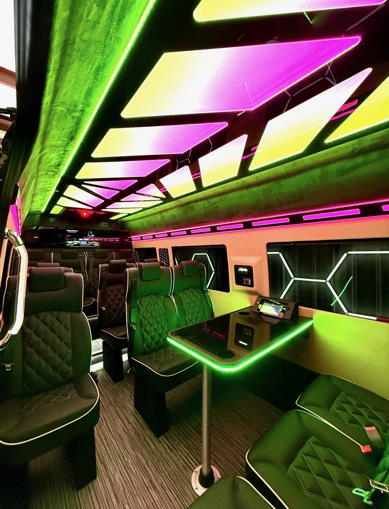 Luxury Sprinter interior in celebration lighting with onboard screens